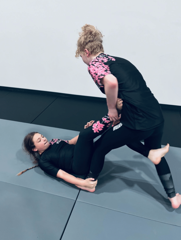 Two kids practicing a no-gi leg lock technique on the mats at Heritage Jiu Jitsu