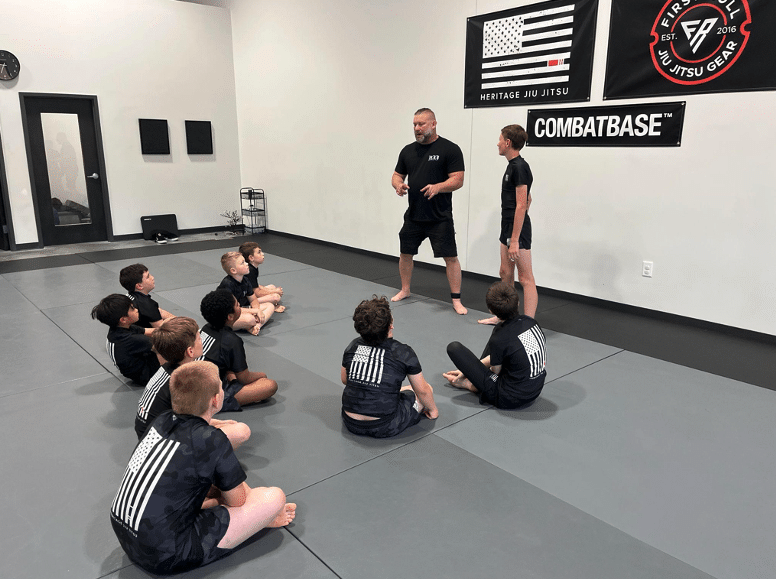 A coach talks with young students seated together during class