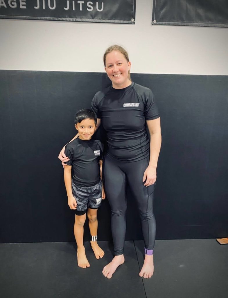 Una madre y su hijo posan juntos con ropa de entrenamiento en Heritage Jiu Jitsu