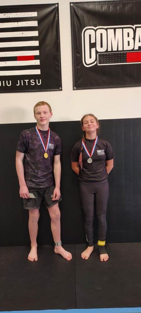 Dos estudiantes posan con medallas después de una competencia de Jiu Jitsu