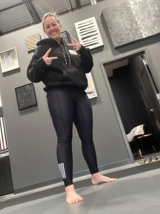 Un miembro de Heritage Jiu Jitsu posa con ropa de entrenamiento dentro de la academia