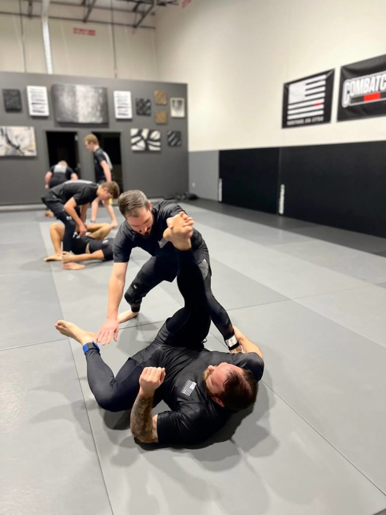 Adultos entrenando un intercambio rápido de llaves de pierna no-gi en el tatami